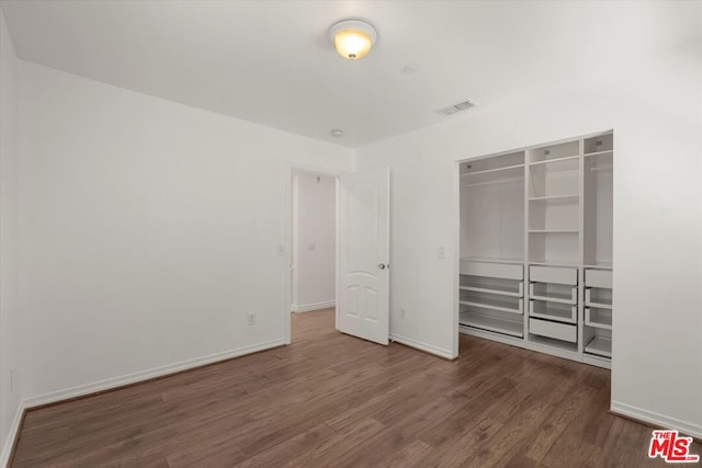 unfurnished bedroom featuring dark hardwood / wood-style floors and a closet