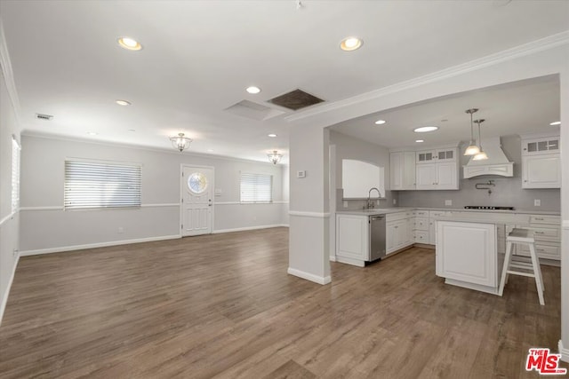 kitchen with white cabinets, a kitchen breakfast bar, custom exhaust hood, stainless steel dishwasher, and black gas stovetop