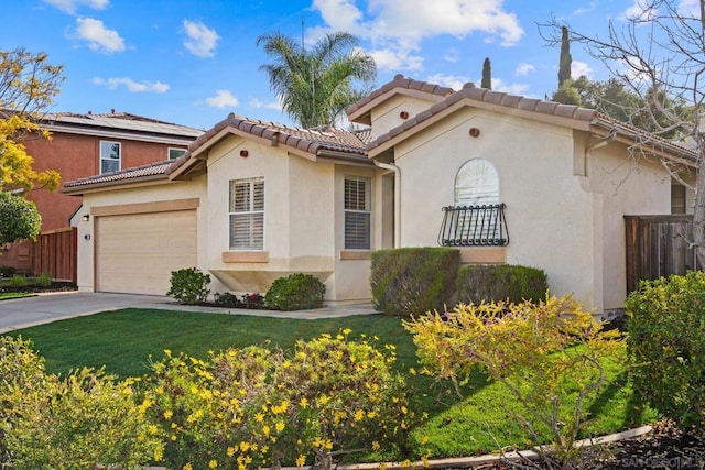 mediterranean / spanish-style house featuring a garage and a front lawn