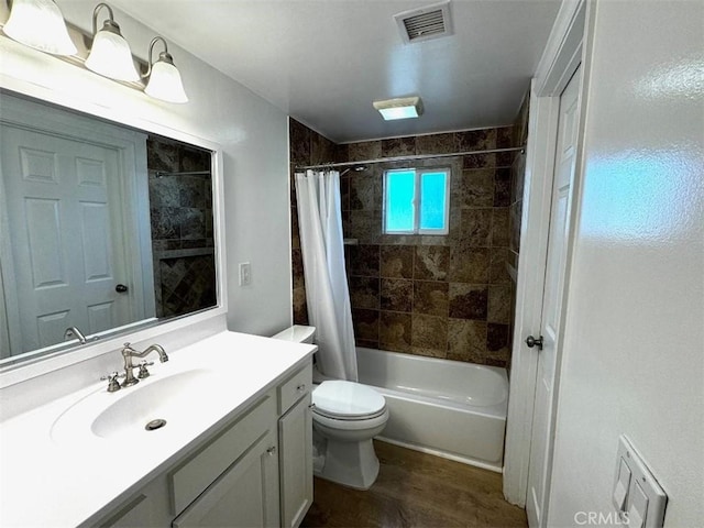 full bathroom featuring hardwood / wood-style flooring, vanity, shower / bath combination with curtain, and toilet