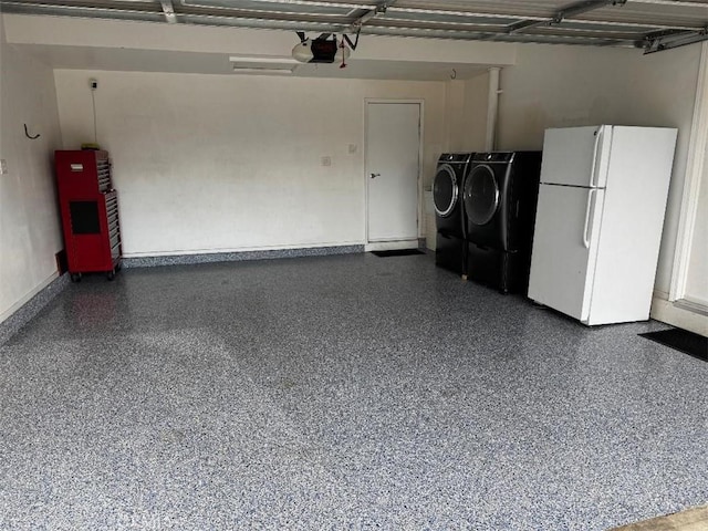 garage with white refrigerator, a garage door opener, and washing machine and dryer