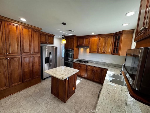 kitchen featuring light stone countertops, appliances with stainless steel finishes, a center island, and decorative light fixtures