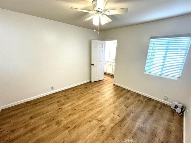 unfurnished room with plenty of natural light, ceiling fan, and light hardwood / wood-style floors