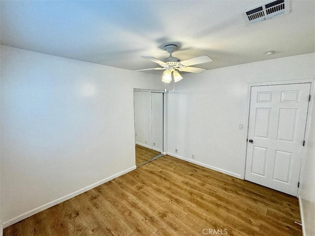 empty room with ceiling fan and hardwood / wood-style floors