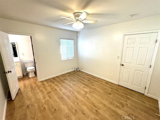 unfurnished bedroom featuring connected bathroom, ceiling fan, and light hardwood / wood-style flooring