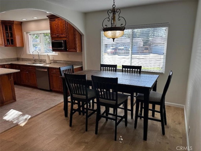 dining space with light hardwood / wood-style floors, sink, and a wealth of natural light