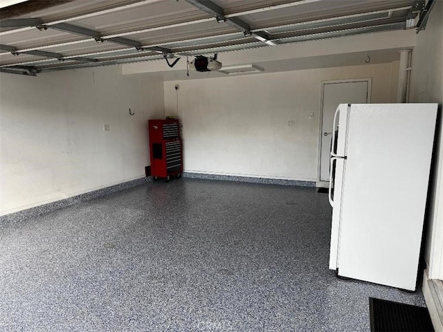 garage featuring a garage door opener and white fridge