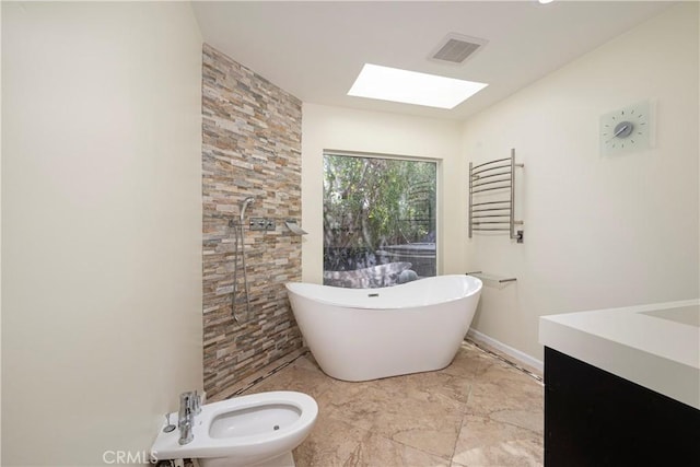 full bath featuring a skylight, a soaking tub, radiator heating unit, vanity, and a bidet