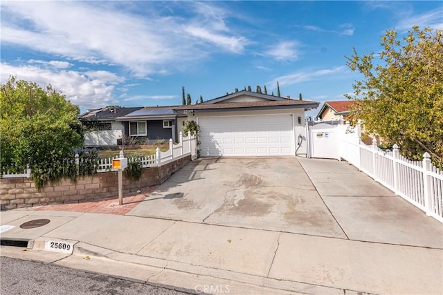 ranch-style house with stucco siding, roof mounted solar panels, fence, a garage, and driveway