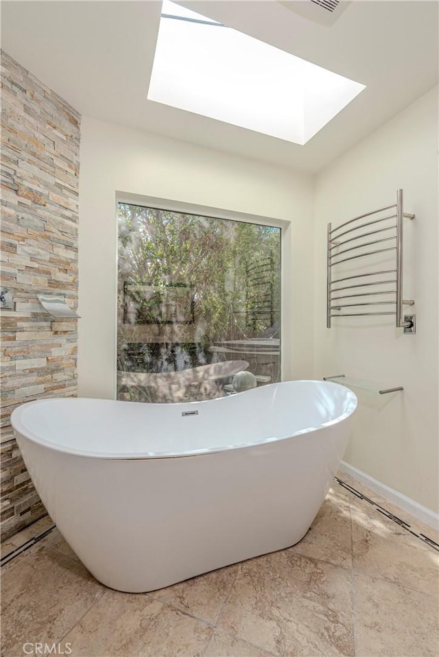 25609 Oakbar Ct, Newhall, CA 91321 - bathroom with a skylight, a freestanding tub, and baseboards