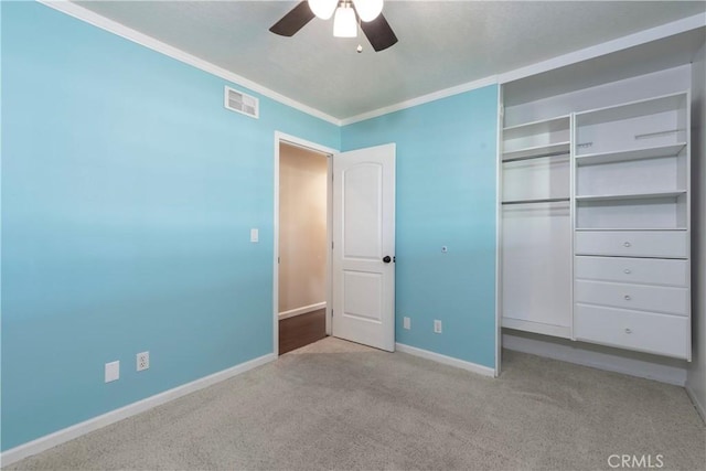 unfurnished bedroom featuring baseboards, visible vents, ornamental molding, carpet, and a closet