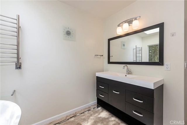 bathroom featuring radiator, vanity, and baseboards