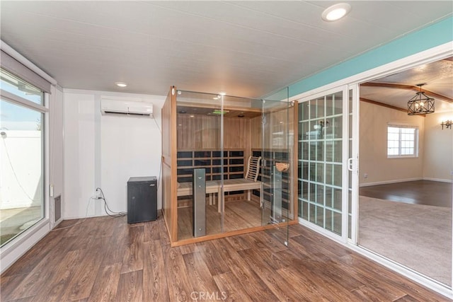 unfurnished office with visible vents, wood finished floors, a wall mounted air conditioner, a chandelier, and recessed lighting