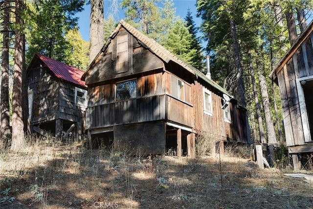 rear view of house featuring an outbuilding