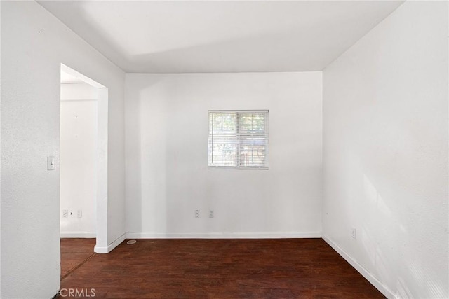 spare room featuring dark wood-type flooring