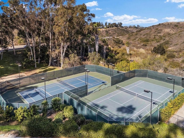 view of sport court with fence and a mountain view