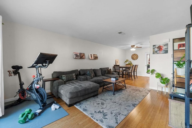 living room with baseboards, ceiling fan, visible vents, and wood finished floors