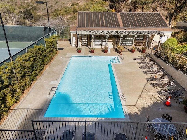 pool with a patio and fence