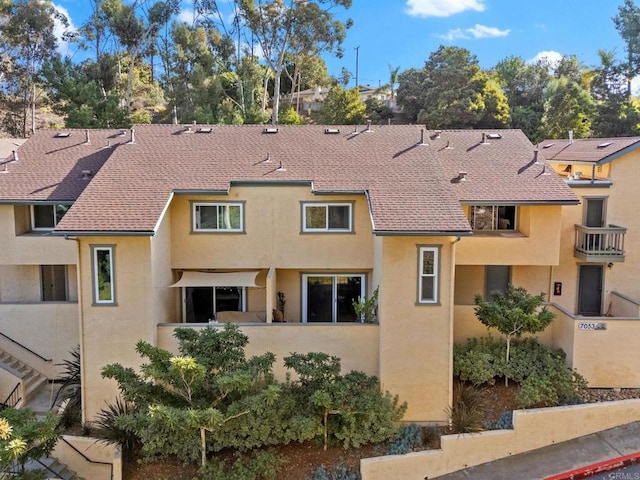 view of front of property featuring roof with shingles and stucco siding