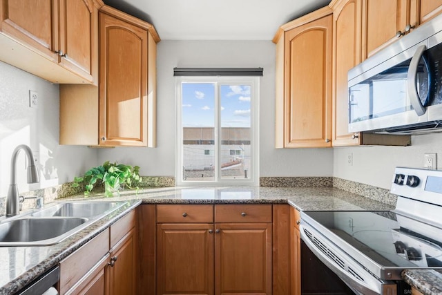 kitchen with stainless steel appliances, sink, and light stone counters