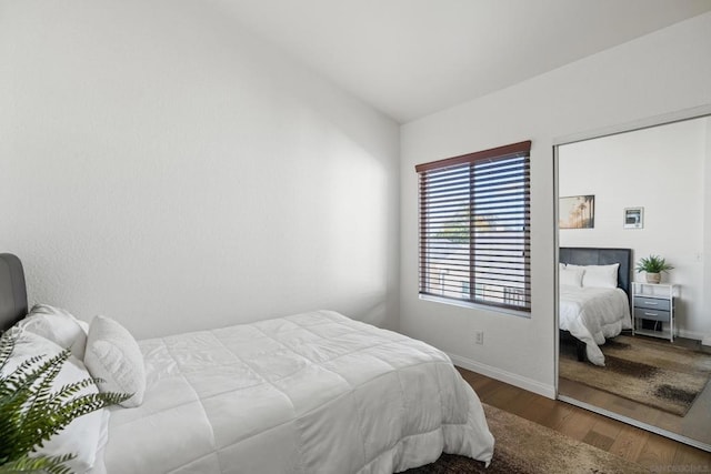 bedroom with dark hardwood / wood-style floors and vaulted ceiling