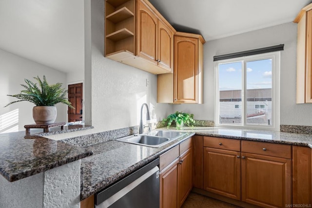 kitchen with sink, stainless steel dishwasher, dark stone counters, and kitchen peninsula