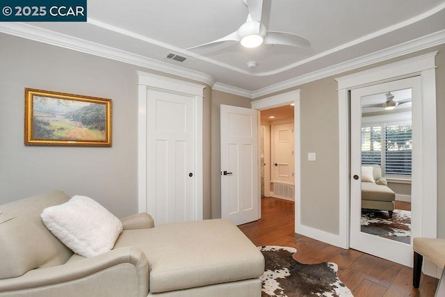 sitting room with hardwood / wood-style flooring, ornamental molding, and ceiling fan