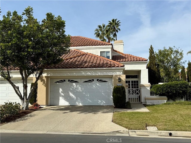 mediterranean / spanish house with a front yard and a garage