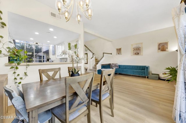 dining space with a chandelier and light hardwood / wood-style flooring