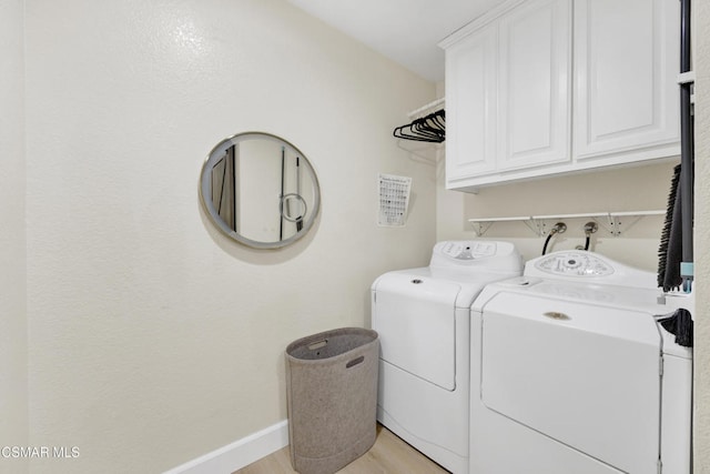 washroom featuring cabinets, independent washer and dryer, and light wood-type flooring