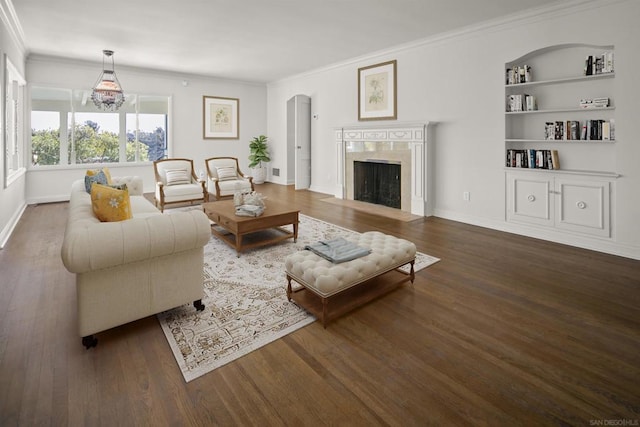 living room with crown molding, dark hardwood / wood-style floors, a high end fireplace, and built in shelves