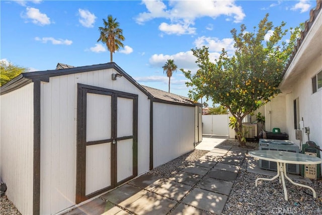 view of shed with central AC and fence