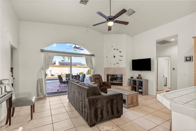 living room with a tile fireplace, visible vents, and light tile patterned floors