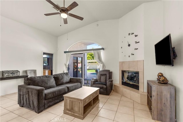 living room with ceiling fan, a fireplace, high vaulted ceiling, and light tile patterned floors