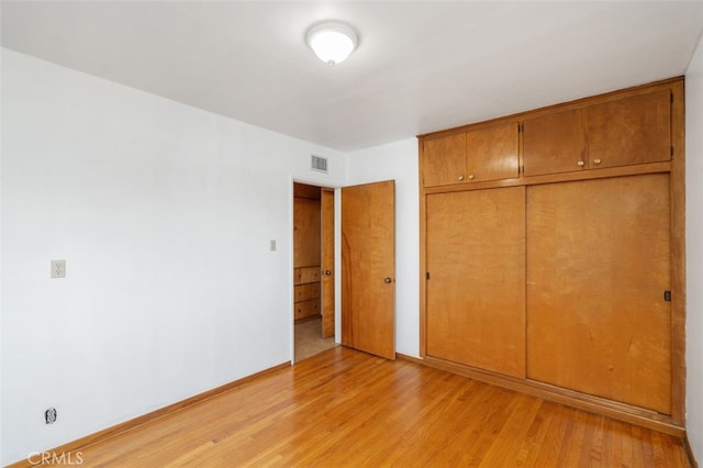 unfurnished bedroom featuring light hardwood / wood-style flooring and a closet