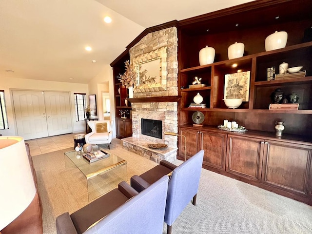 living room with lofted ceiling, a stone fireplace, built in features, and light tile patterned floors