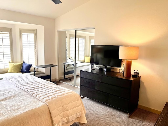 bedroom with light carpet, ceiling fan, vaulted ceiling, and a closet