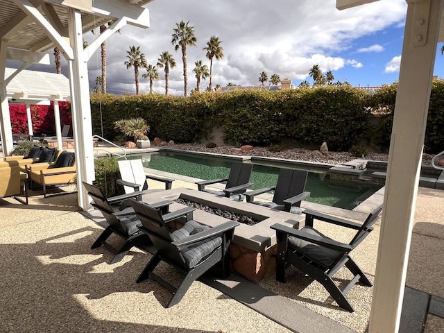 view of patio with a fenced in pool and an outdoor fire pit