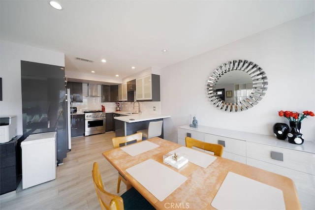 dining area featuring sink and light wood-type flooring