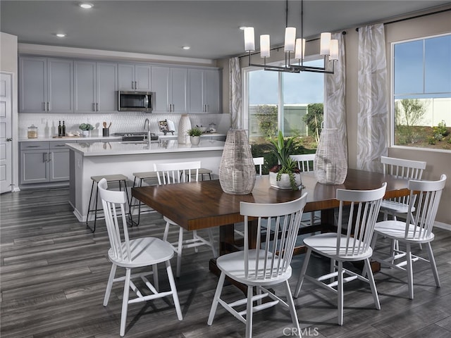 kitchen with backsplash, dark hardwood / wood-style flooring, hanging light fixtures, and gray cabinetry