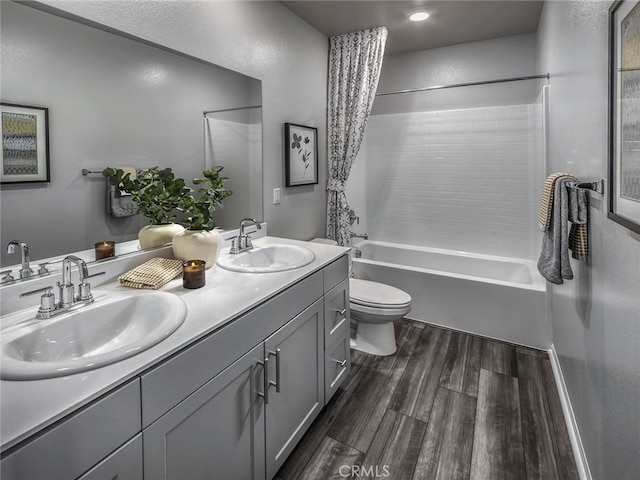 full bathroom with shower / tub combo, vanity, wood-type flooring, and toilet