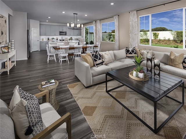 living room with an inviting chandelier and dark hardwood / wood-style flooring