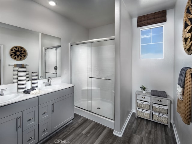 bathroom with vanity, hardwood / wood-style floors, and a shower with door