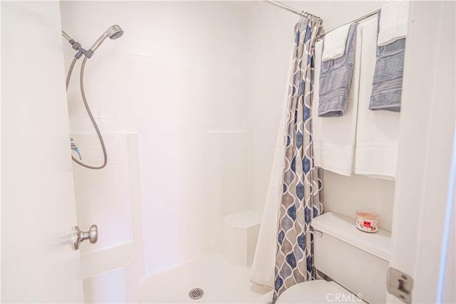 bathroom with a shower with curtain and toilet