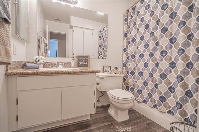 bathroom featuring hardwood / wood-style flooring, vanity, walk in shower, and toilet