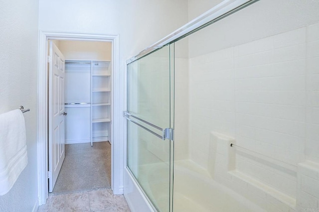 bathroom with tile patterned flooring and combined bath / shower with glass door