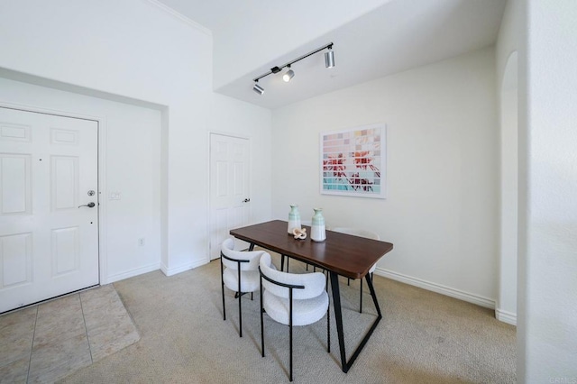 carpeted dining room featuring rail lighting