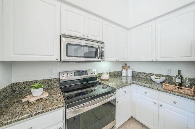 kitchen with dark stone counters, white cabinets, and appliances with stainless steel finishes