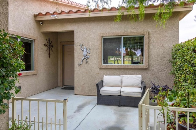 property entrance featuring an outdoor living space and a patio