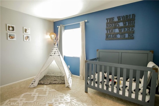 carpeted bedroom featuring a nursery area